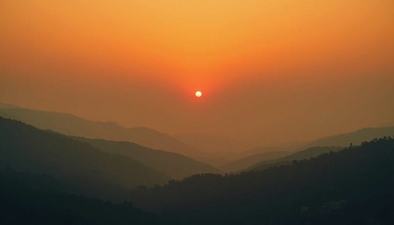 Paisaje montañoso de León cubierto por una densa capa de humo de incendios.